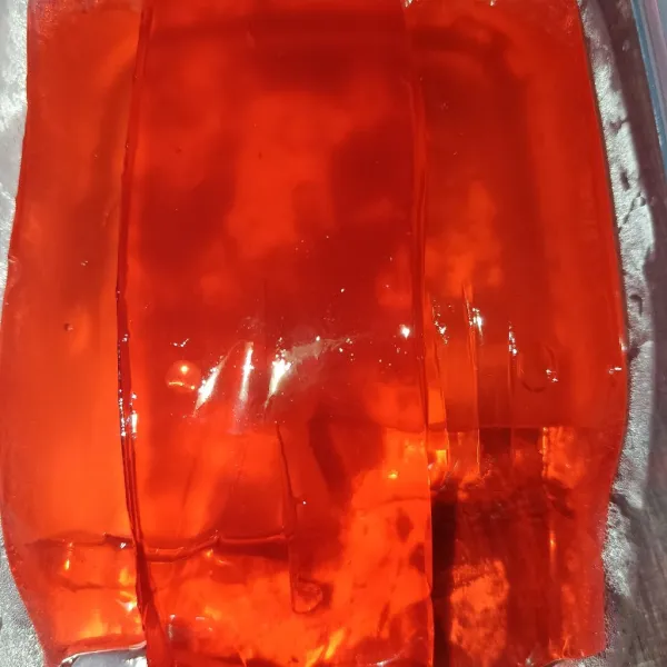 Buat jelly merah sesuai petunjuk kemasan.
