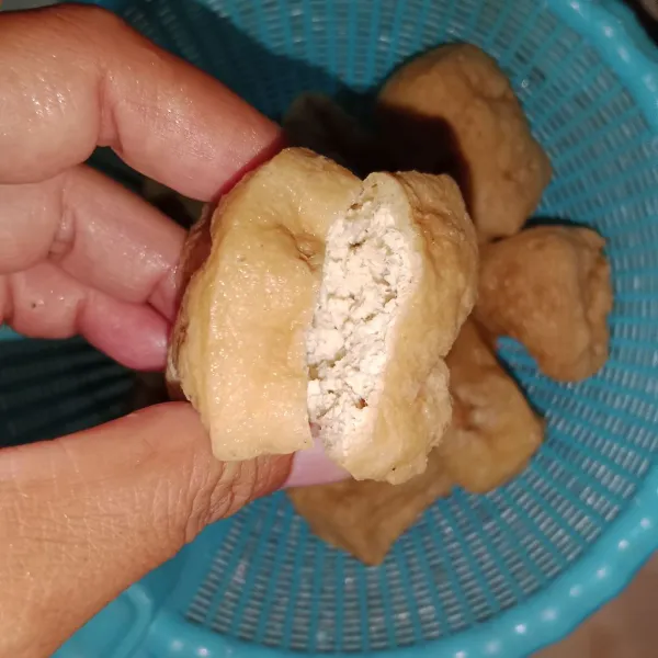 Belah salah satu sisi tahu menggunakan pisau.