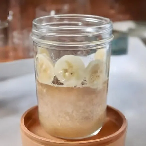 Taruh pisang iris di sisi gelas agar menempel.