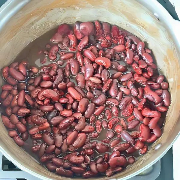 Rebus kacang merah hingga empuk, lalu tiriskan sebagian air dan tambahkan gula, lalu haluskan kacang merah hingga menjadi pasta.