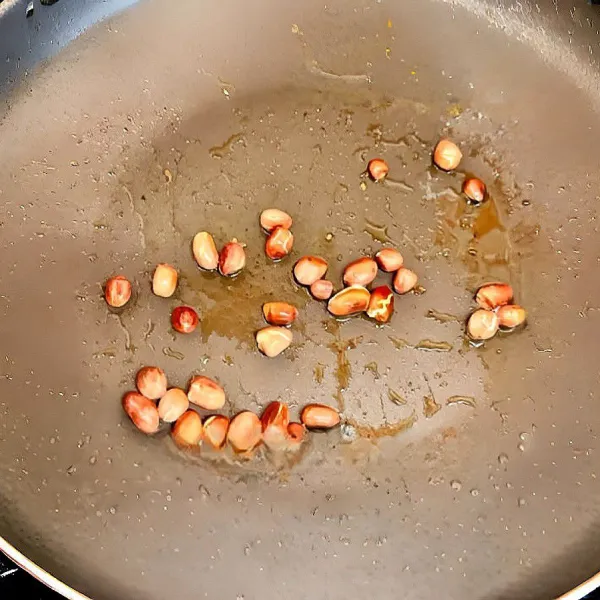 Panaskan sedikit minyak, lalu goreng kacang tanah hingga matang dan harum. Angkat dan tiriskan.