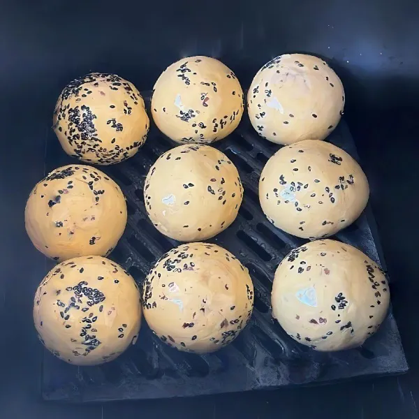 Gulingkan bola pada wijen hitam, olesi tipis dengan minyak. Masukkan ke dalam air fryer, lalu panggang pada suhu 170°C selama 15 menit hingga matang dan berubah warna menjadi keemasan.
