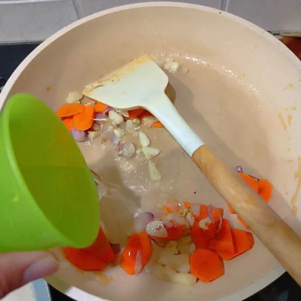 Masukkan wortel, lalu aduk sebentar dan tuangkan air secukupnya. Tumis kembali hingga wortel setengah matang.