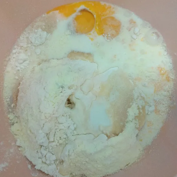 Masukkan telur, tepung terigu, ragi, bread improver, susu bubuk, vanilla susu, susu cair, dan gula pasir. Uleni adonan hingga setengah kalis.
