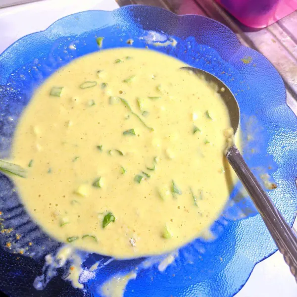 Campurkan terigu, kunyit bubuk, bawang putih bubuk, ketumbar, daun jeruk, garam, dan penyedap. Tambahkan irisan daun bawang. Aduk rata.