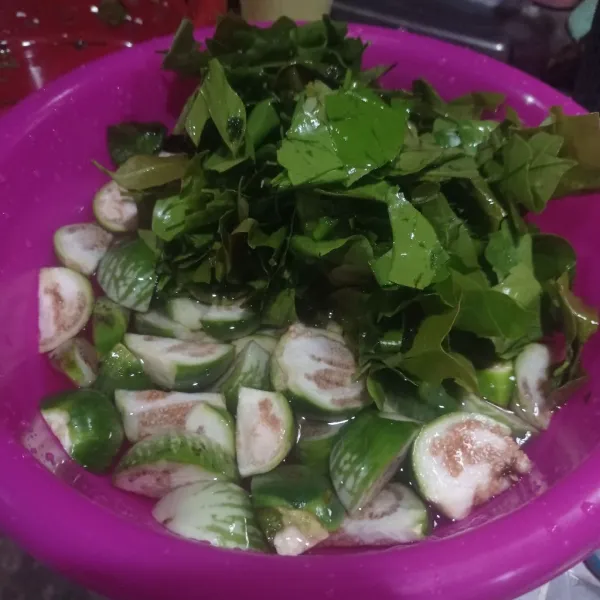 Potong jadi 4 bagian terong, lalu sobek sobek juga daun melinjo, cuci bersih.