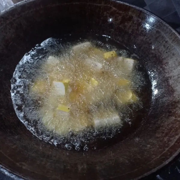 Potong kotak kecil tahu, lalu goreng sampai berkulit.