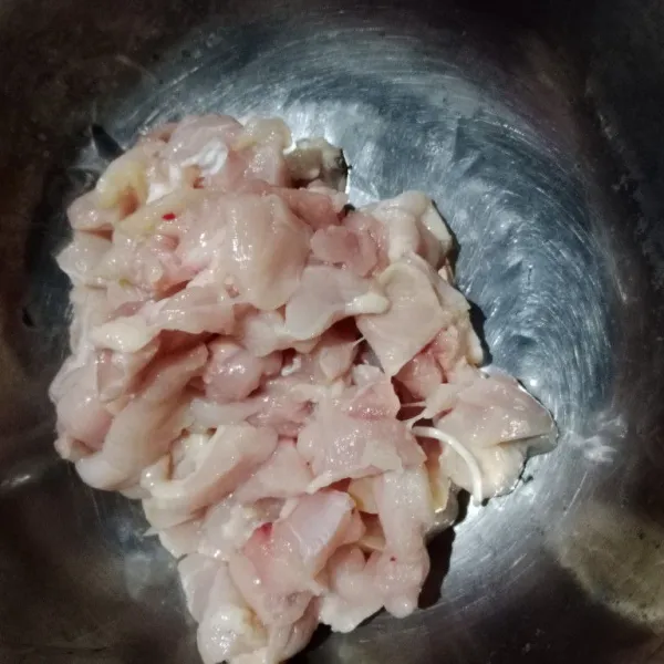 Potong-potong ayam, lalu pisahkan ayam dari tulang dan kulitnya.