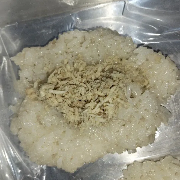 Setelah matang, ambil beras ketan yang sudah matang secukupnya, lalu tambahkan isian ayam di tengahnya.