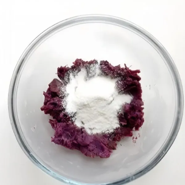 Tambahkan sedikit demi sedikit tepung beras ke dalam ubi ungu halus. Aduk hingga adonan tercampur rata.