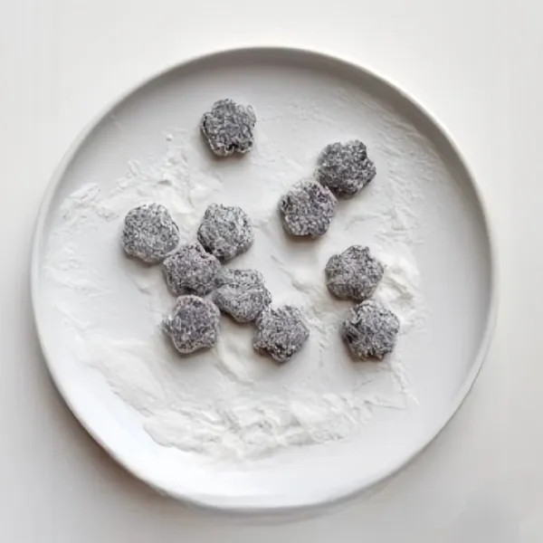 Gulingkan kue ke dalam kelapa parut kering hingga terbaluri rata.