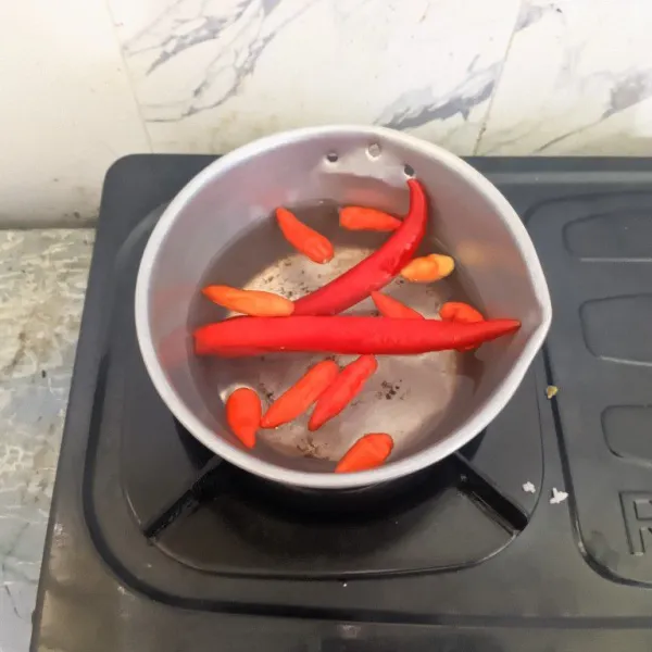 Rebus cabai merah besar dan cabai rawit selama 5 menit, angkat dan sisihkan.