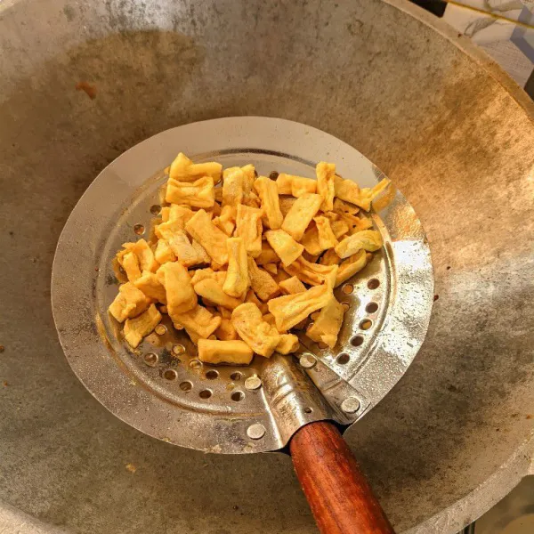 Goreng tahu yang sudah dipotong hingga setengah kering, lalu tiriskan.