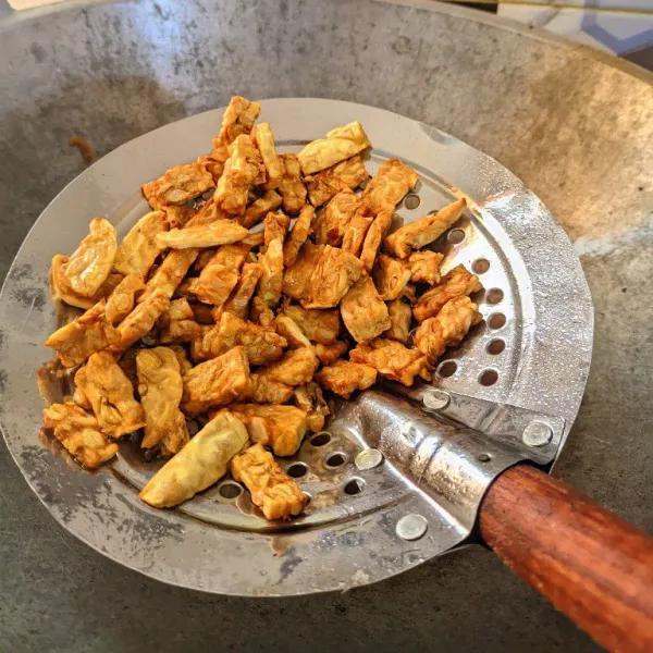 Goreng tempe yang sudah dipotong hingga setengah kering, lalu tiriskan.