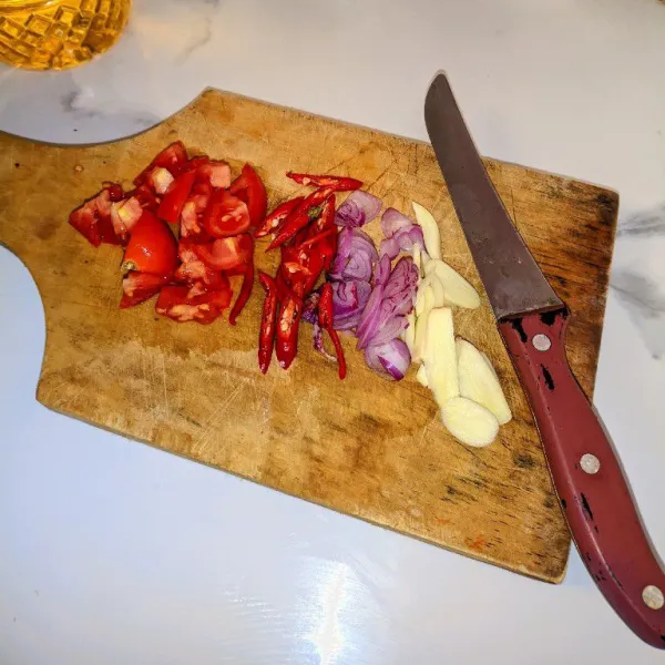 Cincang bawang merah dan bawang putih. Iris serong cabai merah.