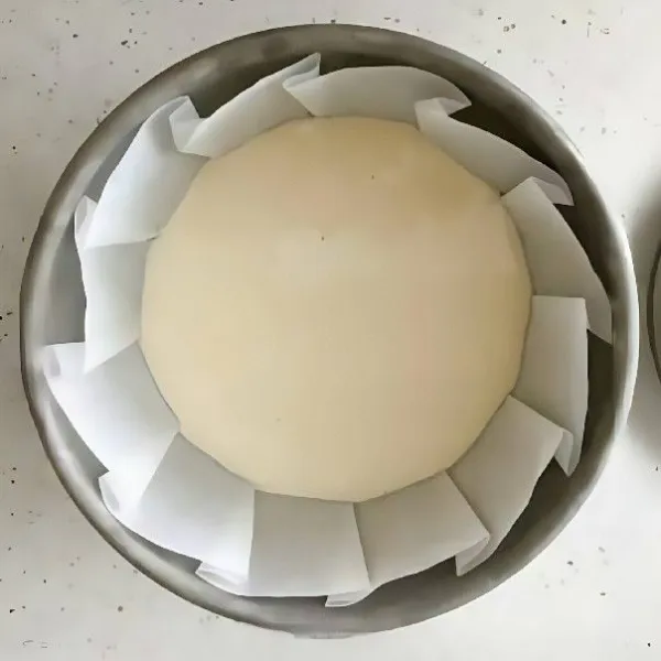 Tuangkan setengah bagian adonan ke dalam loyang. Taburkan sebagian dari daun bawang cincang dan abon di atas adonan.