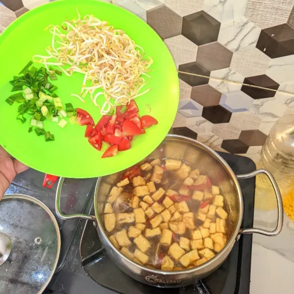Tunggu hingga mendidih. Masukkan tauge, daun bawang, dan tomat yang sudah diiris.