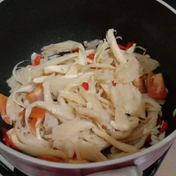 Tambahkan air dan jamur. Masak hingga layu, aduk rata.