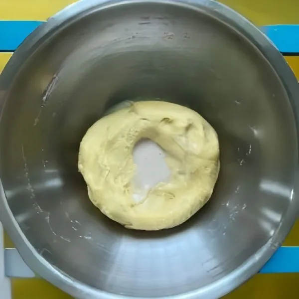 Tambahkan ragi instan yang sudah dilarutkan dalam susu hangat, uleni hingga adonan kalis.