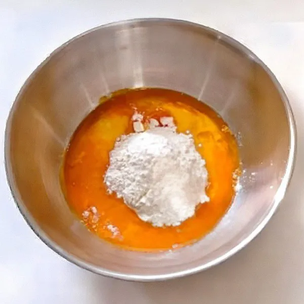 Campurkan 6 butir kuning telur, susu cair, minyak jagung, dan tepung terigu rendah protein. Aduk rata hingga tidak ada gumpalan.