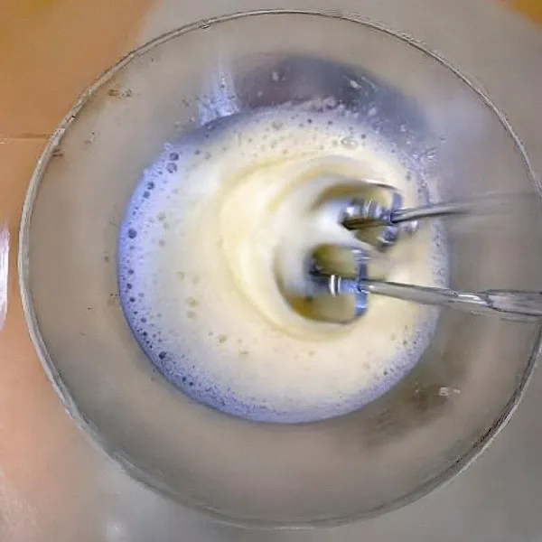 Kocok 6 butir putih telur dengan gula pasir hingga mengembang kaku dan membentuk soft peak.