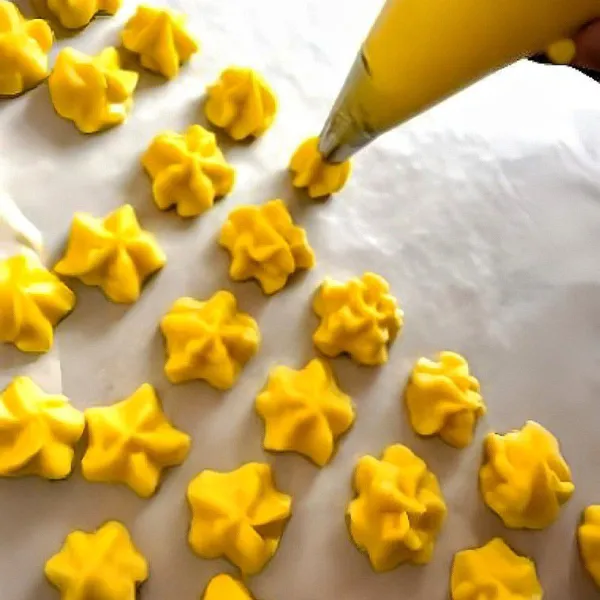 Semprotkan adonan di atas loyang yang sudah dialasi kertas panggang dan bentuk sesuai selera.