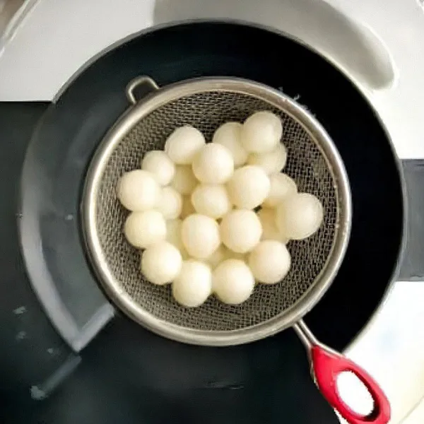 Didihkan air, lalu rebus bola ketan hingga mengapung dan matang. Angkat dan tiriskan.