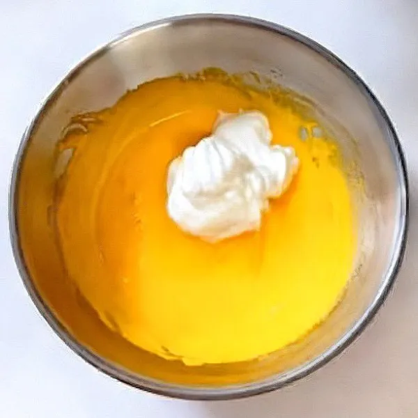 Ambil sedikit putih telur, lalu campurkan ke dalam adonan kuning telur dan aduk hingga rata.