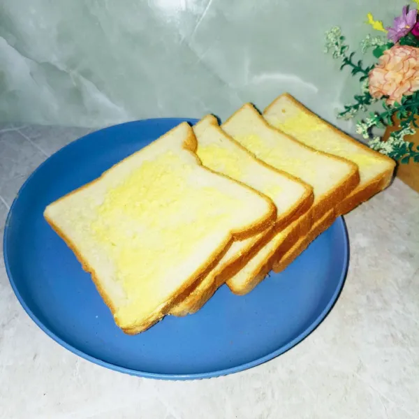 Oleskan roti dengan mentega.