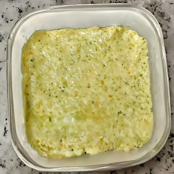 Olesi cetakan dengan minyak kenari. Tuangkan adonan ke dalam loyang, lalu tutup loyang dengan plastik wrap dan tusuk permukaannya. Kukus dalam panci selama 25 menit dengan api sedang.