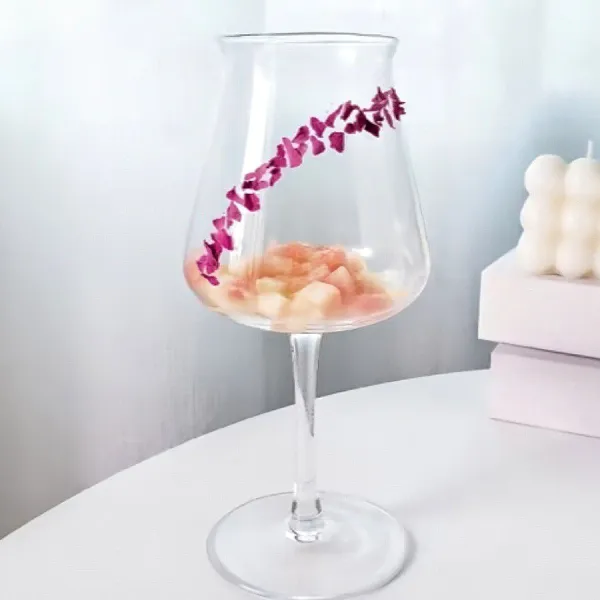 Olesi bagian dalam gelas dengan madu, lalu taburi dengan sedikit remah mawar .