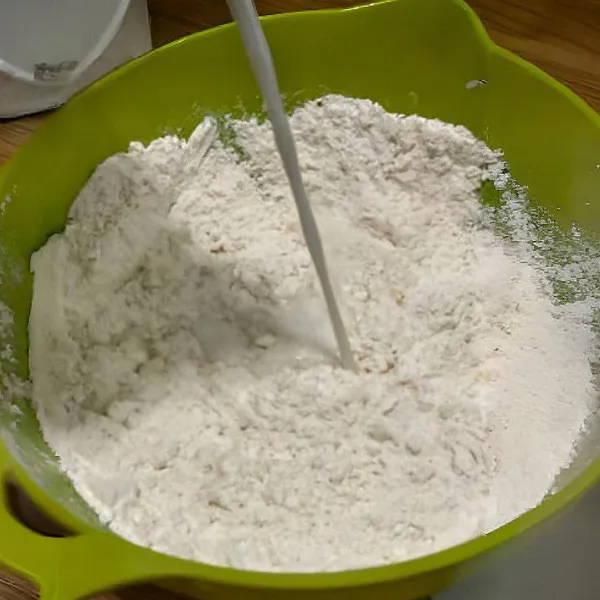 Tuangkan susu cair, lalu uleni hingga menjadi adonan kalis.