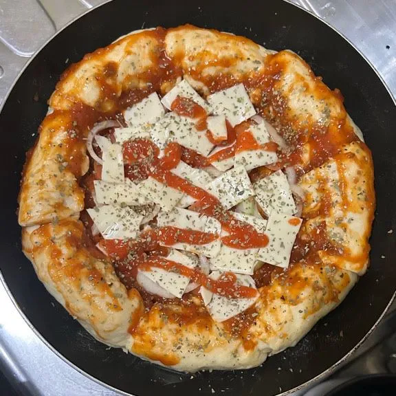 Tusuk-tusuk bagian tengah dengan garpu agar tidak menggelembung saat di panggang, lalu beri topping seperti saus spaghetti yang dioles di semua permukaan, beri potongan sosis dan keju mozarella slice dan terakhir saus pedas beserta oregano. Panggang selama 30 menit dengan api kecil.