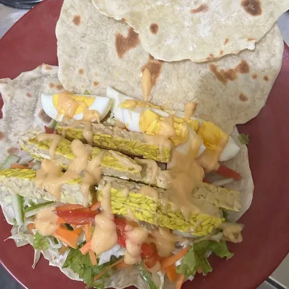 Tata kulit tortilla, lalu isi dengan sayur yang telah dipotong sebelumnya dan berikan saus salad diatasnya.