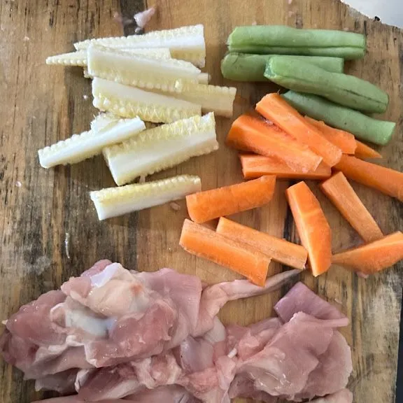 Potong-potong ayam fillet tipis memanjang dan potong sayur memanjang.