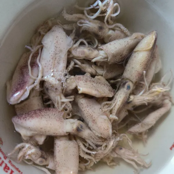 Rendam cumi asin dengan air panas, diamkan beberapa saat kemudian potong-potong dan bilas dengan air mengalir hingga bersih.