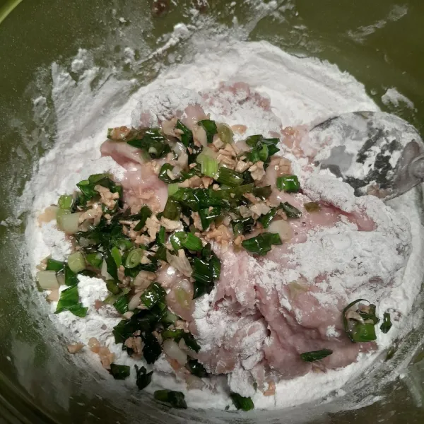 Masukkan bawang putih dan daun bawang yang sudah digoreng. lalu aduk hingga rata.