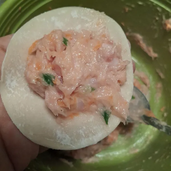 Ambil selembar kulit dimsum, lalu masukkan satu sendok makan adonan dan lipat bagian pinggir kulit dimsum.