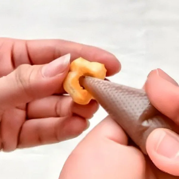 Setelah matang, biarkan puff agak dingin, lalu lubangi bagian bawah dan semprotkan 35 gr puree blueberry sebagai isian.