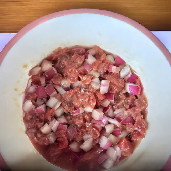 Campurkan daging sapi cincang dengan bawang bombay, arak masak, kecap asin, saus tiram, minyak wijen, tepung maizena, dan minyak goreng. Aduk hingga rata.