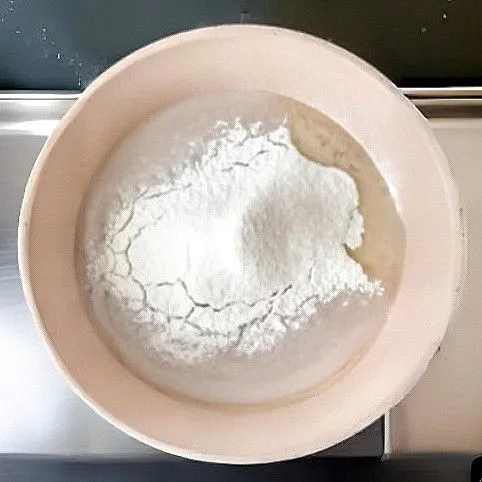 Matikan api, lalu masukkan 35 gr tepung terigu dan 13 gr tepung maizena. Aduk cepat hingga menjadi adonan kalis dan tidak lengket.