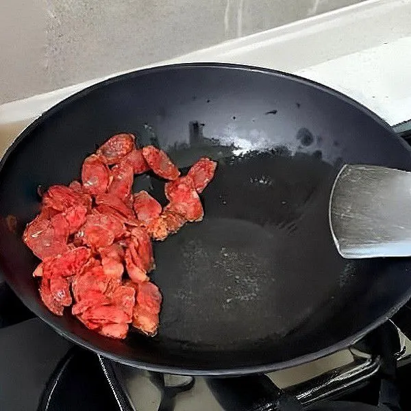 Panaskan wajan, tumis 150 gr sosis kering hingga harum.