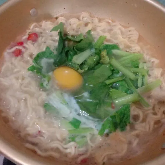 Selanjutnya masukkan sayur sawi hijau dan telur ayam. Aduk rata.