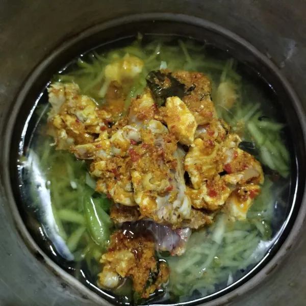 Masukkan irisan labu siam, lalu tambahkan air secukupnya dan aduk sampai rata.