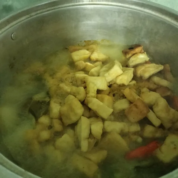 Masukkan irisan tahu dan tempe yang sudah di goreng, lalu tambahkan garam, penyedap rasa, gula pasir, dan santan. Aduk sampai rata dan masak hingga matang.