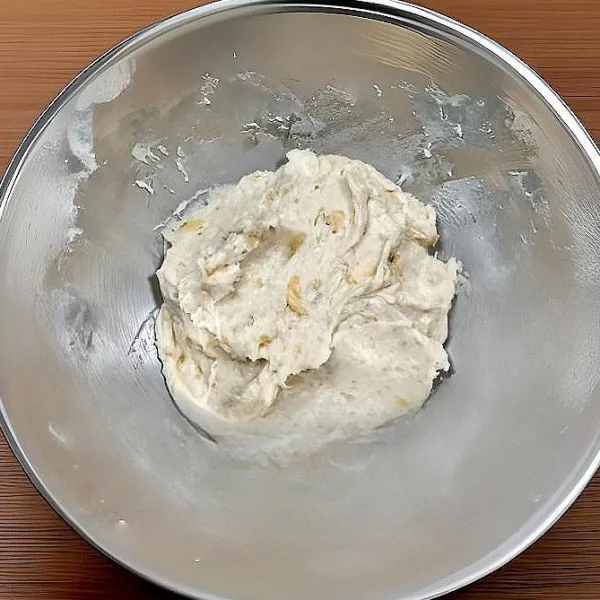 Masukkan ragi instan, garam, dan baking powder ke dalam adonan pisang, lalu aduk hingga rata.