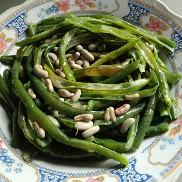 Tata kacang panjang yang telah dibelah dalam piring saji.