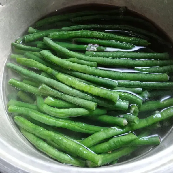 Didihkan air secukupnya untuk merebus kacang panjang. Rebus hingga empuk. Angkat dan tiriskan.