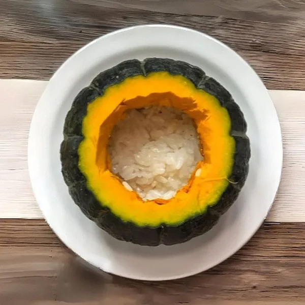 Masukkan sepertiga ketan ke dasar labu, ratakan.