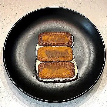 Susun 3 keping biskuit di atas piring. Oleskan krim ke atas biskuit dengan merata.